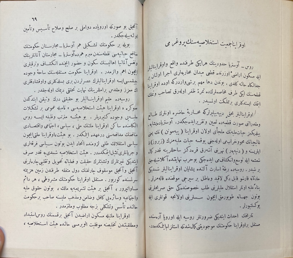 A two-page spread of white paper with black text in Arabic script. On the right-hand page there is a title at the top in larger font.